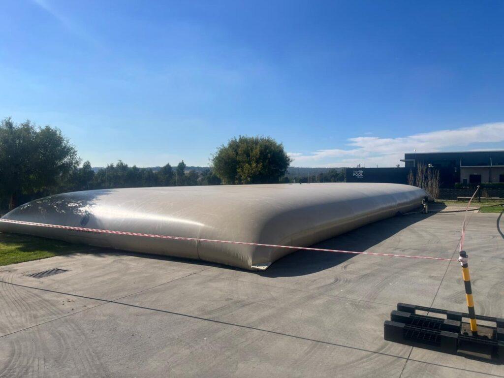 Large flexible PVC water bladder installed at a mining site for industrial water storage and operational water supply.
