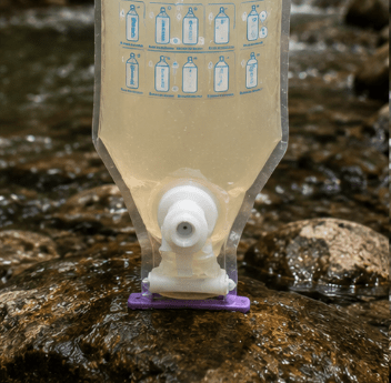 PuriBag during the water purification process with contaminants separating from clean water.